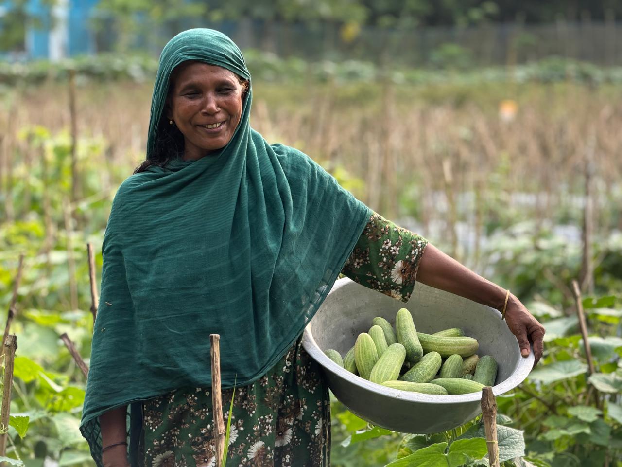 Smiling woman carrying harvested fresh produce